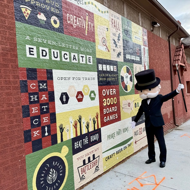 Mr. Monopoly next to Spielbound's iconic mural