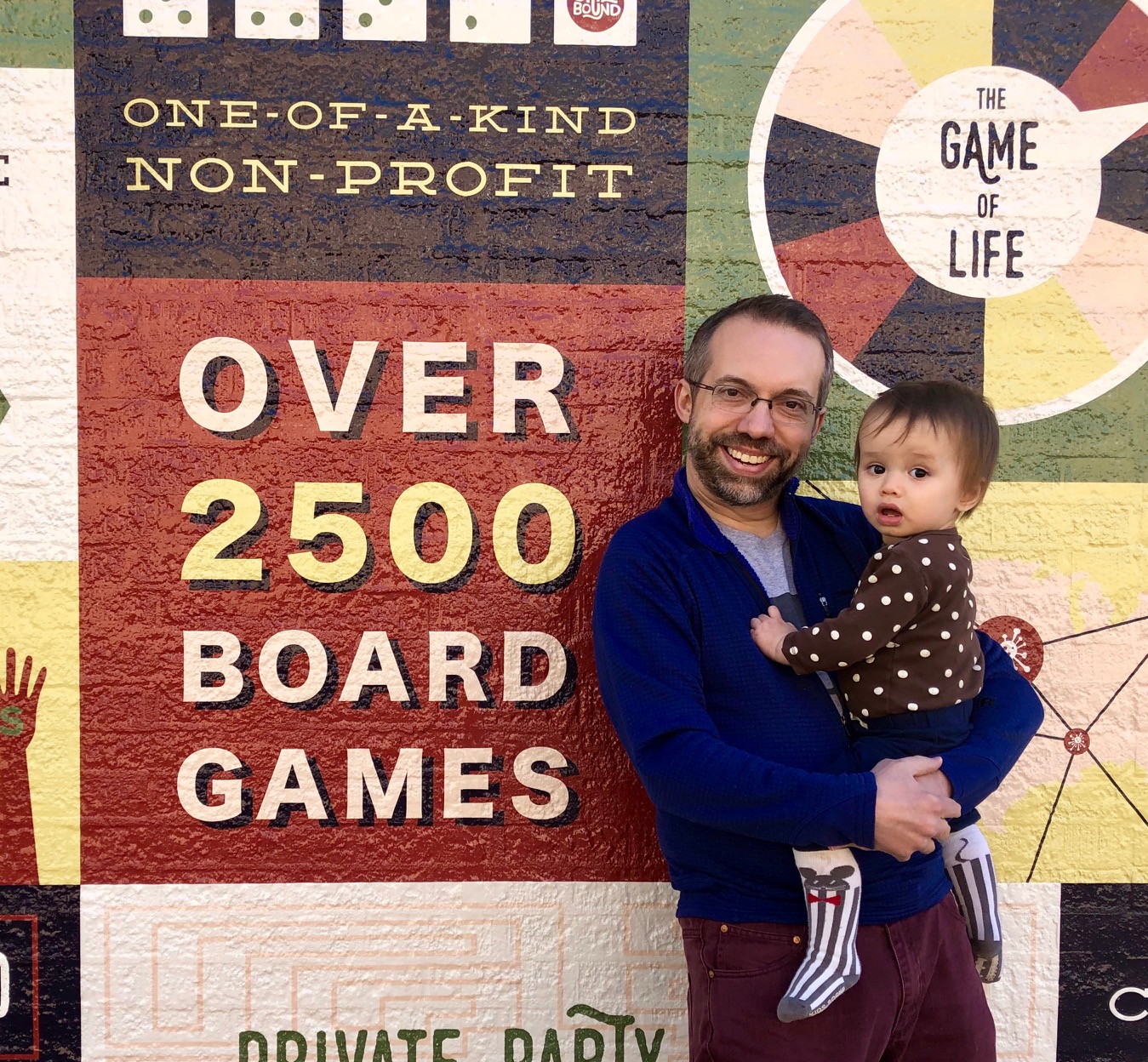 Kaleb and his daughter Mercury in front of the Spielbound mural.